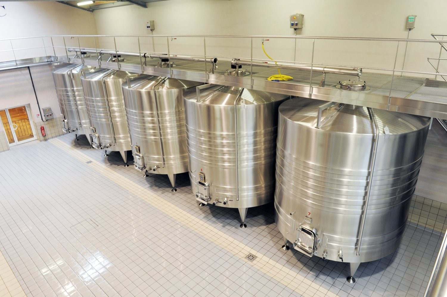Czysta hala produkcji spożywczej ze stalowymi zbiornikami i jasną posadzką
